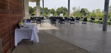 Grey Selection High Back Folding Chairs set up spaced apart to help with social distancing and table with white tablecloth and decor 